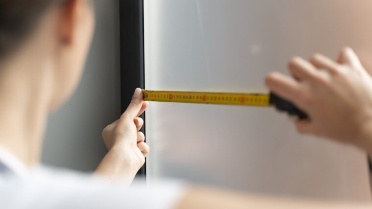 Man som mäter fönster